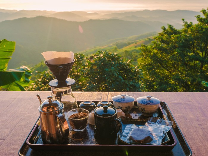 Tray of coffee and mugs overlooking mountain views.
